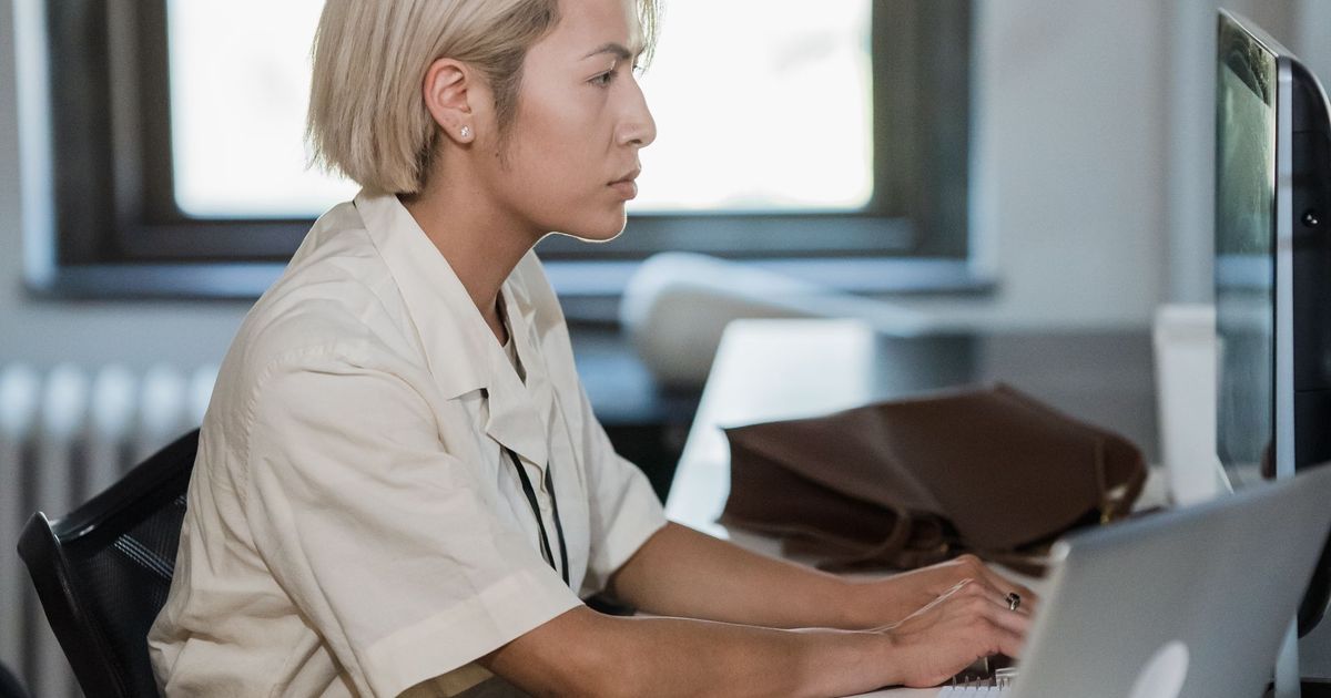 Vrouw die geconcentreerd typt aan een computer op kantoor