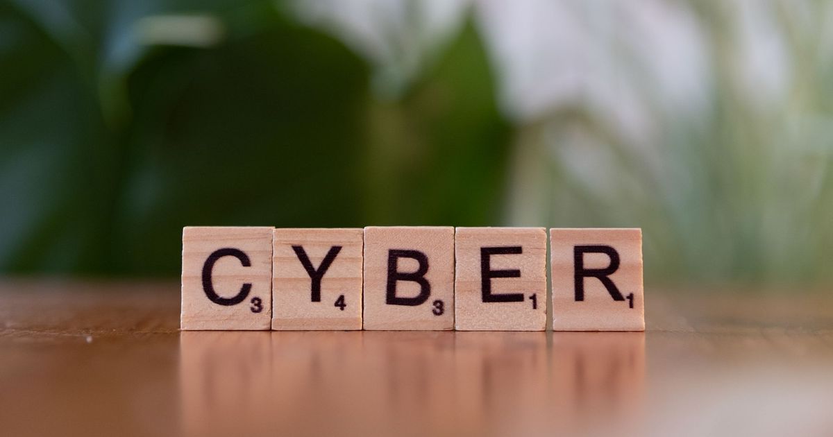 Houten lettertegels die het woord CYBER vormen