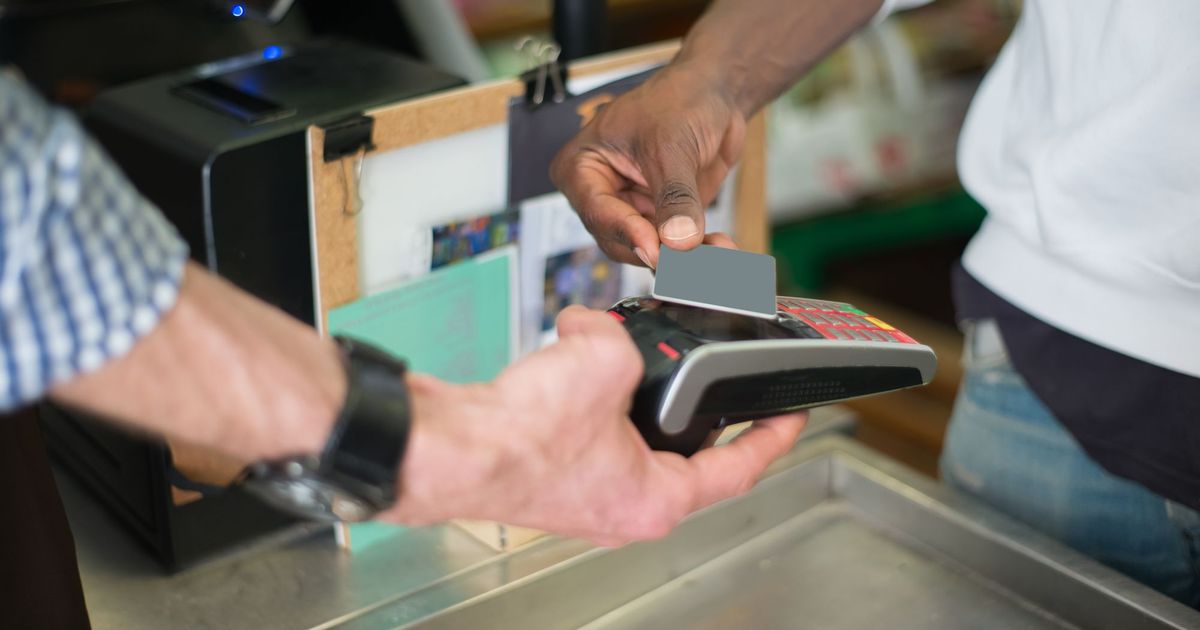 Een klant betaalt contactloos met een kaart aan een betaalterminal aan de toonbank