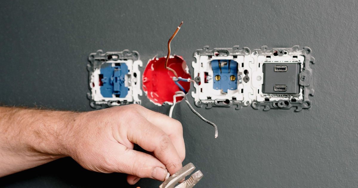 Een elektricien werkt aan een stopcontact