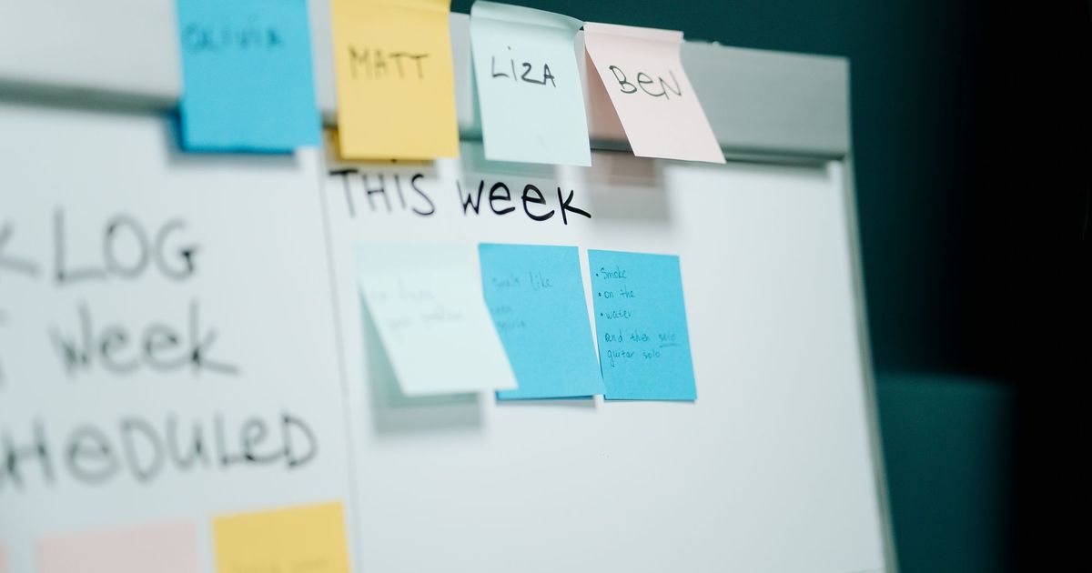 Whiteboard met een weekplanning en gekleurde plakbriefjes