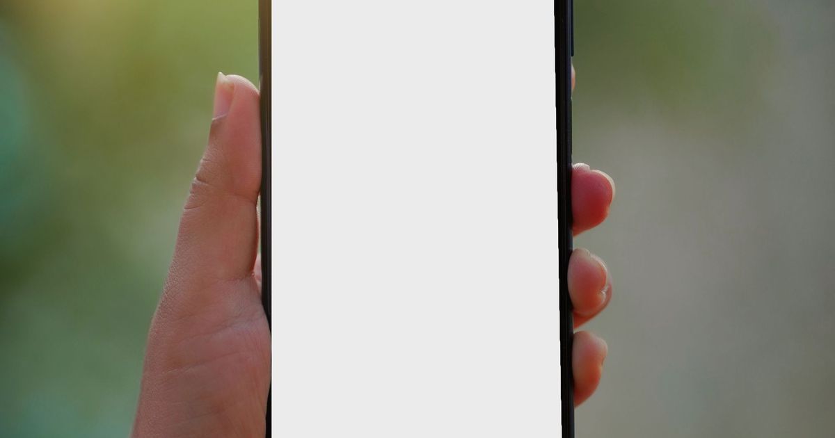 Hand die een smartphone met een leeg wit scherm vasthoudt