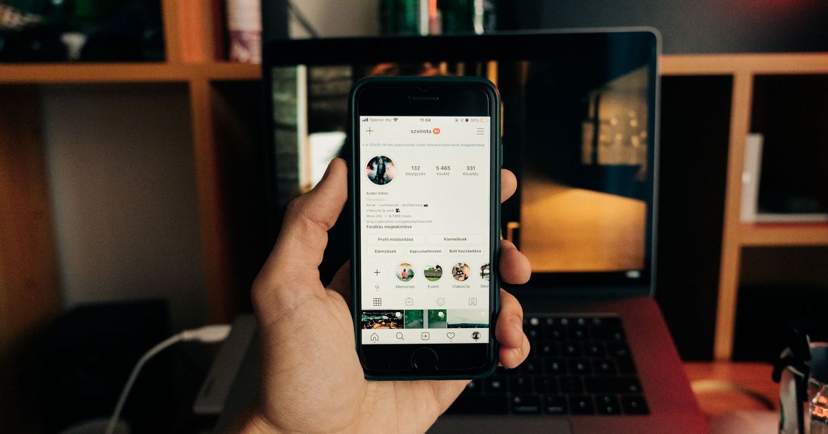 Hand met een smartphone met een sociale-mediaprofiel open