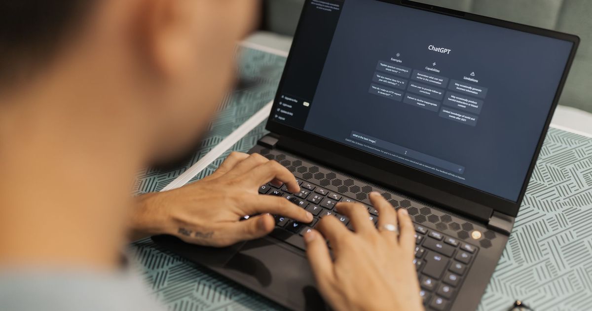 Iemand werkt op een laptop met een AI-assistent open op het scherm